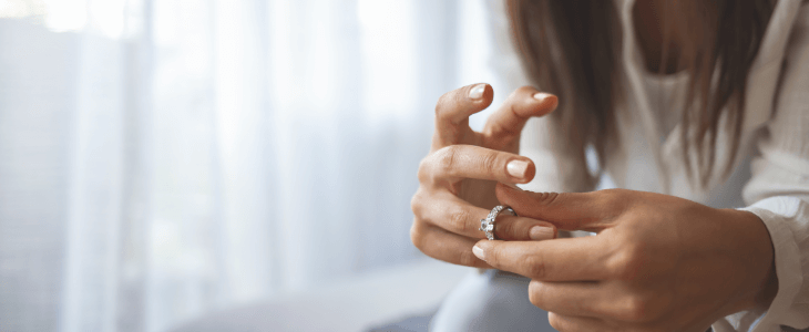 Woman contemplating divorce by pulling off her rings