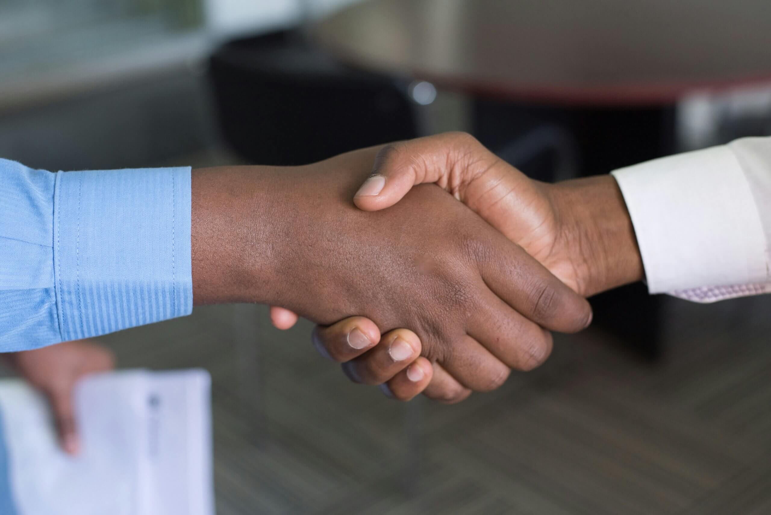 Close-up of a handshake between two people in a professional setting